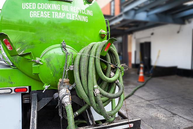 worker pumping grease trap at commercial kitchen in Burleson, TX